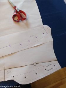 Mønsterdeler som viser sideåpning med knapper, en påtrykt, en håndtegnet.